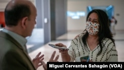 En la imagen aparece haciendo una entrevista con su teléfono la periodista Isabel Mercado, reportera en Tijuana, México. [Foto: Miguel Cervantes Sahagún/ VOA]