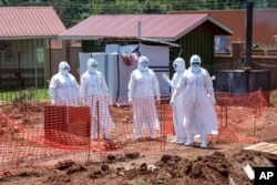 Doctors walk inside the Ebola isolation section of Mubende Regional Referral Hospital, in Mubende, Uganda on Sept. 29, 2022. (AP Photo/Hajarah Nalwadda, File)