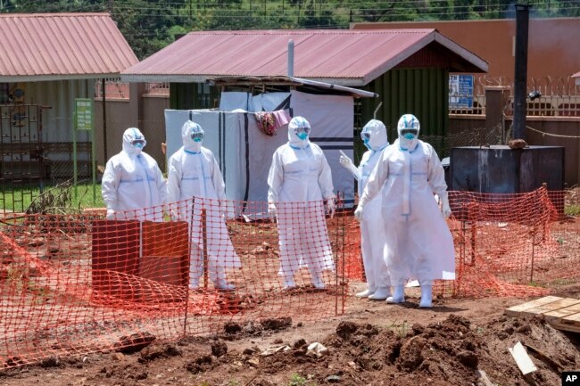 Doctors walk inside the Ebola isolation section of Mubende Regional Referral Hospital, in Mubende, Uganda on Sept. 29, 2022. (AP Photo/Hajarah Nalwadda, File)