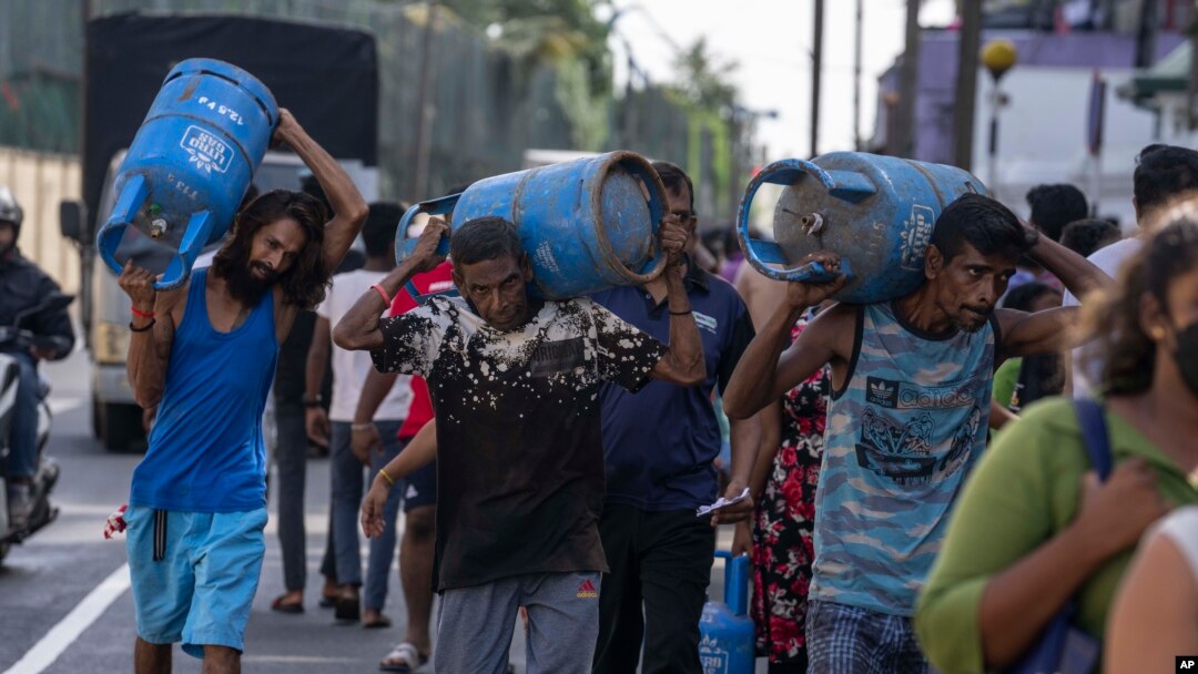 سری لنکا میں گیس کے بحران کے دوران لوگ گیس کے سلنڈر خرید کر گھروں کو جارہے ہیں: فوٹو اے پی