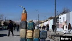FILE - Cans containing gasoline are kept for sale on a road in Kabul, Afghanistan, Jan. 27, 2022