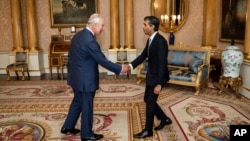 El rey Carlos III da la bienvenida a Rishi Sunak durante una audiencia en el Palacio de Buckingham, Londres, donde invitó al recién elegido líder del Partido Conservador a convertirse en primer ministro y formar un nuevo gobierno, el martes 25 de octubre de 2022. 
