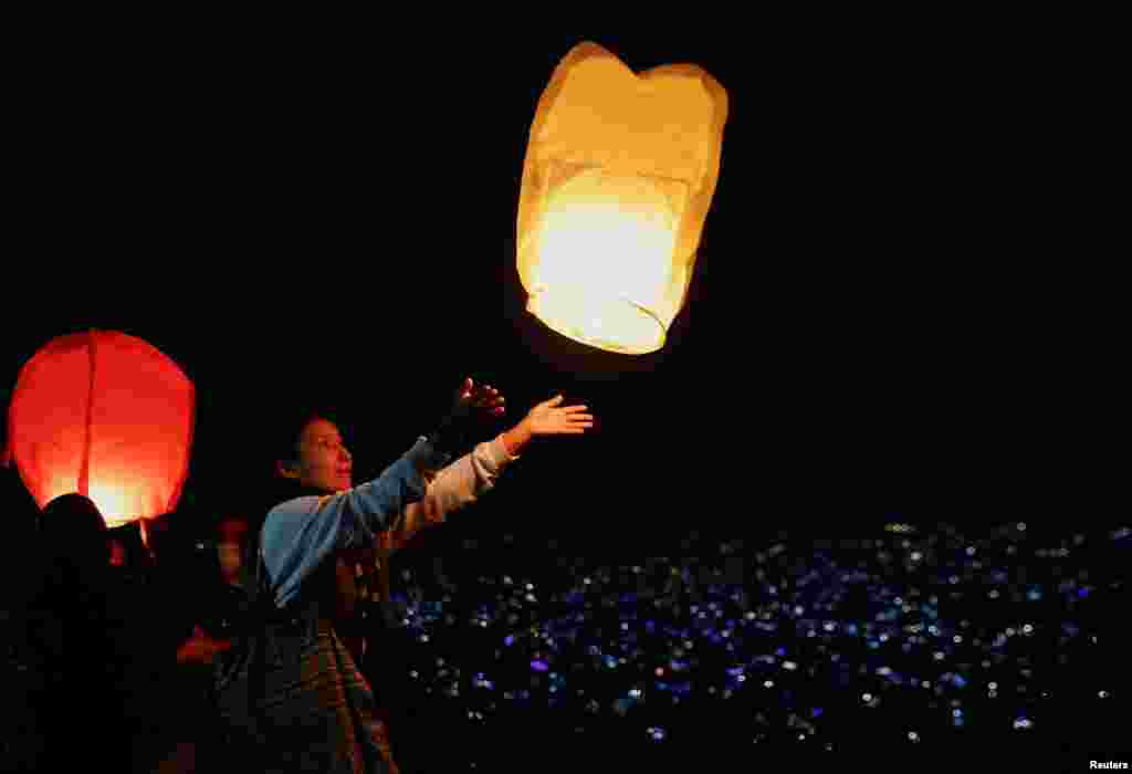 A woman releases a lantern from a hilltop during the Tihar festival, the Hindu festival of lights, in Kathmandu, Nepal.