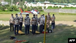 Indo-Tibetan Border Police (ITBP) personnel stand in position during preparations for a rescue operation for missing climbers struck by an avalanche, at the ITBP Matli helipad station Oct. 5, 2022. 