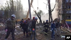 在这张照片中，救援人员在2022年10月9日乌克兰扎波罗热被炮击损毁的建筑现场工作。