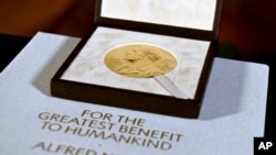 FILE - The Nobel diploma and medal in physiology or medicine presented to Charles M. Rice is displayed, Dec. 8, 2020, during a ceremony in New York.