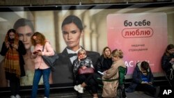 La gente se sienta en una estación del metro, usándola como refugio antiaéreo, en Kiev, Ucrania, el 19 de octubre de 2022.