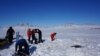 Sejumlah peneliti mengebor lapisan es Danau Hazen di Artik untuk mengampil sampel dalam penelitian mengenai dampak perubahan iklim pada peningkatan risiko penyebaran virus. Pengambilan sampel tersebut dilakukan pada 29 Mei 2017. (Foto: AFP/Graham COLBY)