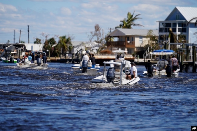 Boats operated by residents help evacuate residents who stayed behind on Pine Island, in the aftermath of Hurricane Ian in Matlacha Fla., Sunday, Oct. 2, 2022. (AP Photo/Gerald Herbert, File)