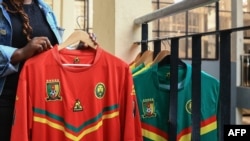 Un commerçant tenant un maillot de football camerounais en vente au marché central de Yaoundé, le 23 septembre 2022.