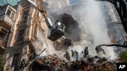 Firefighters work after a drone attack on buildings in Kyiv, Ukraine, Monday, Oct. 17, 2022. (AP Photo/Roman Hrytsyna)