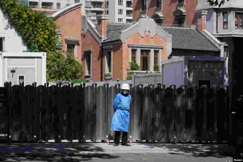 A security guard in a protective suit stands guard in front of a gate, following the COVID-19 outbreak, in Shanghai, China2.