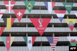 A building is decorated with the flags of the teams participating in the 2022 FIFA World Cup in the Qatari capital Doha, Oct. 11, 2022.