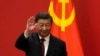 中國領導人習近平站在中共黨旗前。