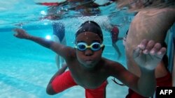 In this still image from an AFP video, a student of Bishop John T. Walker School for Boys attends a free swimming lesson at Ferebee-Hope Aquatic Center in Washington, Oct. 12, 2022.