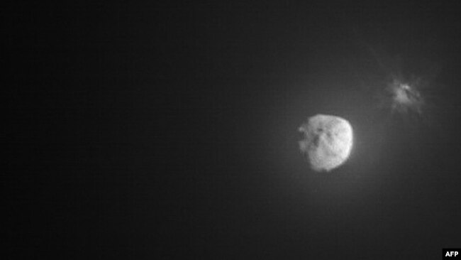 This handout picture obtained by the Italian Space Agency's LICIACube shows the intentional collision of NASA's Double Asteroid Redirection Test mission with its target asteroid, Dimorphos, on Sept. 26, 2022.
