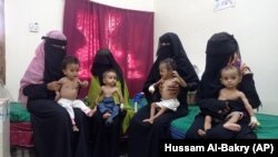 Para ibu menggendong anak mereka yang kekurangan gizi di Rumah Sakit Pedesaan Hays di Hodeida, Yaman, 11 Oktober 2022. (AP Photo/Hussam Al-Bakry)