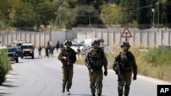 Israeli military forces work near the site where a soldier was killed by gunfire near the West Bank Jewish settlement of Shavei Shomron, Oct. 11, 2022. 