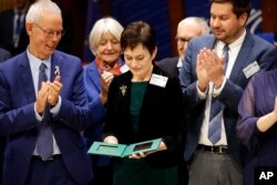 Evgenia Kara-Murza, center, wife of Russian opposition activist, Vladimir Kara-Murza, holds the the Vaclav Havel Human Rights Prize won by his husband, awarded at the Parliamentary Assembly of the Council of Europe in Strasbourg, eastern France, Oct. 10, 2022.