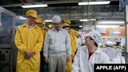 资料照：苹果CEO库克（左）参观富士康在郑州的苹果手机生产线。（法新社2012年3月28日）