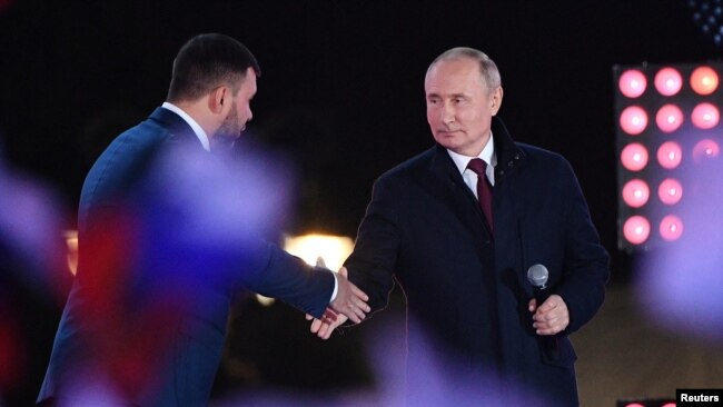 Russian President Vladimir Putin, right, and Denis Pushilin, the Russian-installed leader in Ukraine's Donetsk region, attend a concert marking the declared annexation of four Ukraine territories, in Moscow's Red Square, Sept. 30, 2022. (Sputnik/Maksim Blinov/Pool via Reuters)