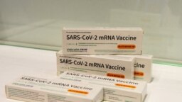 FOTO FILE: Kotak vaksin messenger RNA (mRNA) COVID-19 produksi Walvax Biotechnology di pameran dagang di Shanghai, China, 16 April 2021. (China Daily via REUTERS)