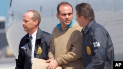 En esta fotografía tomada el 13 de mayo de 2008, el líder de las fuerzas paramilitares de Colombia, Salvatore Mancuso, es escoltado por miembros de la agencia antinarcóticos de Estados Unidos tras su extradición desde el país suramericano.