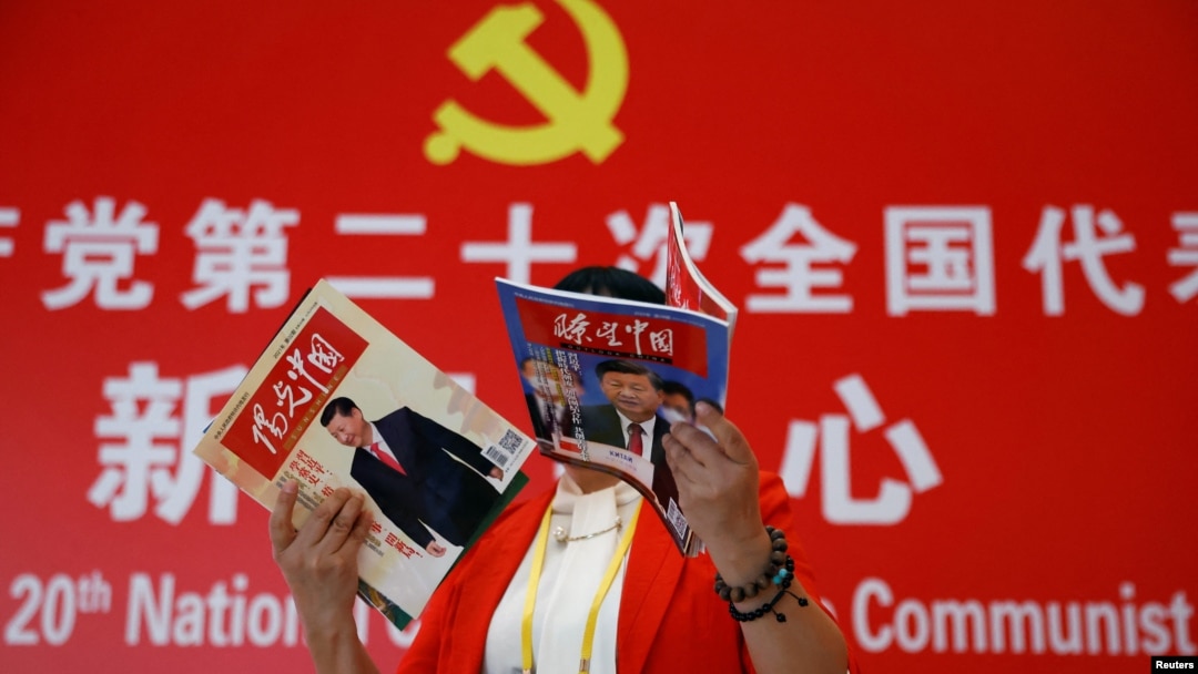 资料照：一名记者在北京一家酒店的中共二十大新闻中心阅读有着中国领导人习近平照片封面的杂志。（2022年10月19日）