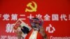 资料照：一名记者在北京一家酒店的中共二十大新闻中心阅读有着中国领导人习近平照片封面的杂志。（2022年10月19日）