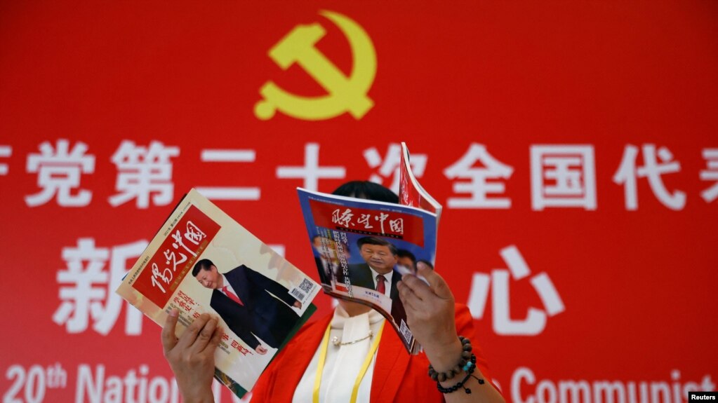 一名记者在北京一家酒店的中共二十大新闻中心阅读有着中国领导人习近平照片封面的杂志。（2022年10月19日）(photo:VOA)