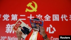 一名记者在北京一家酒店的中共二十大新闻中心阅读有着中国领导人习近平照片封面的杂志。（2022年10月19日）
