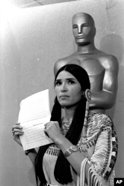 FILE - Sacheen Littlefeather tells the audience at the Academy Awards ceremony in Los Angeles, March 27, 1973, that Marlon Brando was declining to accept his Oscar as best actor for his role in 'The Godfather.'