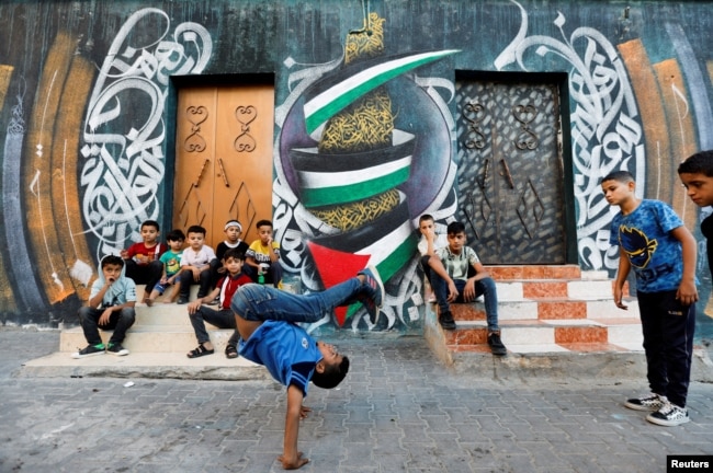 A Palestinian boy performs breakdancing on the street in Nusseirat refugee camp in central Gaza Strip, October 14, 2022. (REUTERS/Ibraheem Abu Mustafa)