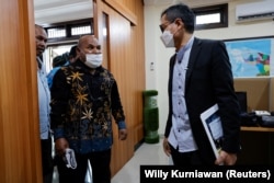 Gubernur Papua Lukas Enembe berbicara di samping Direktur Eksekutif Amnesty International Indonesia Usman Hamid dalam pertemuan di Jakarta, 27 Mei 2022. (Foto: REUTERS/Willy Kurniawan)