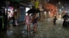 Sejumlah warga berjalan menembus banjir di tengah hujan yang terus turun sebelum topan Sitrang menerjang Dhaka, Bangladesh, pada 24 Oktober 2022. (Foto: Reuters/Mohammad Ponir Hossain)