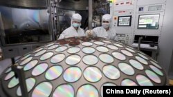 FILE - Employees work on a semiconductor chip production line at Jiangsu Azure Corp in Huaian, Jiangsu province, China, March 25, 2022. (China Daily via Reuters)