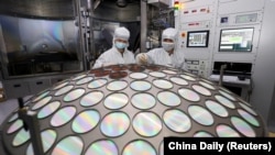 资料图片：位于中国江苏省淮安市的江苏蔚蓝公司的员工在半导体芯片生产线上工作。（2022 年3月25日）