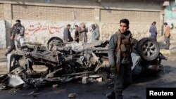 فائل فوٹو ؒ: ایک افغان پولیس افسر 10 جنوری 2021 کو کابل، افغانستان میں بم دھماکے کی جگہ پر نظر رکھے ہوئے ہے۔