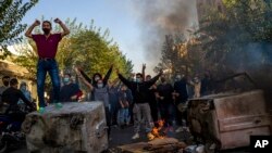 FILE - In this photo taken by someone not employed by The Associated Press, Iranians protest the death of Mahsa Amini in Tehran on Oct. 27, 2022. A human rights group reported Nov. 24, 2023, that Iran had executed and buried a man in connection with the protests.