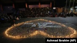 Supporters of soccer club Arema FC pray for the victims of Saturday's soccer match in Malang, Indonesia, Oct. 3, 2022. (AP/Achmad Ibrahim)