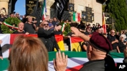 People perform a roman salute in the hometown of former dictator Benito Mussolini to mark the 100th anniversary of the coup d'etat by which he sized power in 1922, in Predappio, Italy, Oct. 30, 2022.