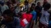 Warga Haiti membantu seorang jurnalis yang terkena gas air mata yang ditembakkan oleh polisi selama aksi protes atas kematian seorang jurnalis Romelo Vilsaint, di Port-au-Prince, Haiti, 30 Oktober 2022 (foto: dok). 