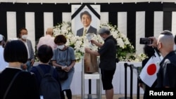 Mourners offer flowers at the altar outside Nippon Budokan Hall, which is hosting a state funeral for former Prime Minister Shinzo Abe in Tokyo, Sept. 27, 2022. 