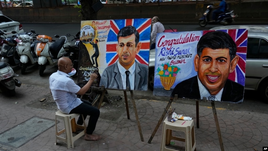印度艺术教师萨加尔·坎布里正在孟买街头绘制里希·苏纳克的画像，庆祝这位英国印度裔新首相的当选。（2022年10月25日）(photo:VOA)