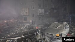 Seorang petugas penyelamat bekerja di lokasi bangunan tempat tinggal yang rusak berat akibat serangan rudal Rusia di kota Zaporizhzhia, Ukraina, 10 Oktober 2022.