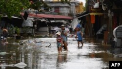 People wade through a flooded market after Typhoon Noru made landfall in Hoi An, Vietnam's Quang Nam Province on Sept. 28, 2022.