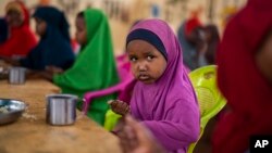 A child eats at a school in Dollow, Somalia, Sept. 19, 2022. At midday, dozens of hungry children from the camps try to slip into a local primary school where the World Food Program offers a rare lunch program for students.