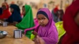 FILE - A child eats at a school in Dollow, Somalia, Sept. 19, 2022. At midday, dozens of hungry children from the camps try to slip into a local primary school where the World Food Program offers a lunch program for students.