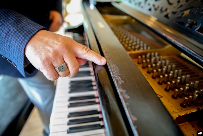 Robert Friedman points out possible bite marks from Thomas Edison on a Steinway grand piano once owned by the inventor, on Sept. 28, 2022, in Woodstock, N.Y.. (AP Photo/Michael Hill)