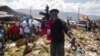 FILE - Barbecue, the leader of the G9 and Family gang, stands next to garbage to call attention to the conditions people live in as he leads a march against kidnapping through La Saline neighborhood in Port-au-Prince, Haiti, Oct. 22, 2021.